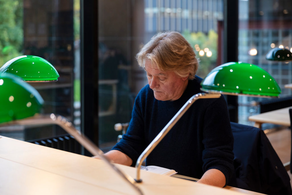 Mann som leser i et bibliotek.