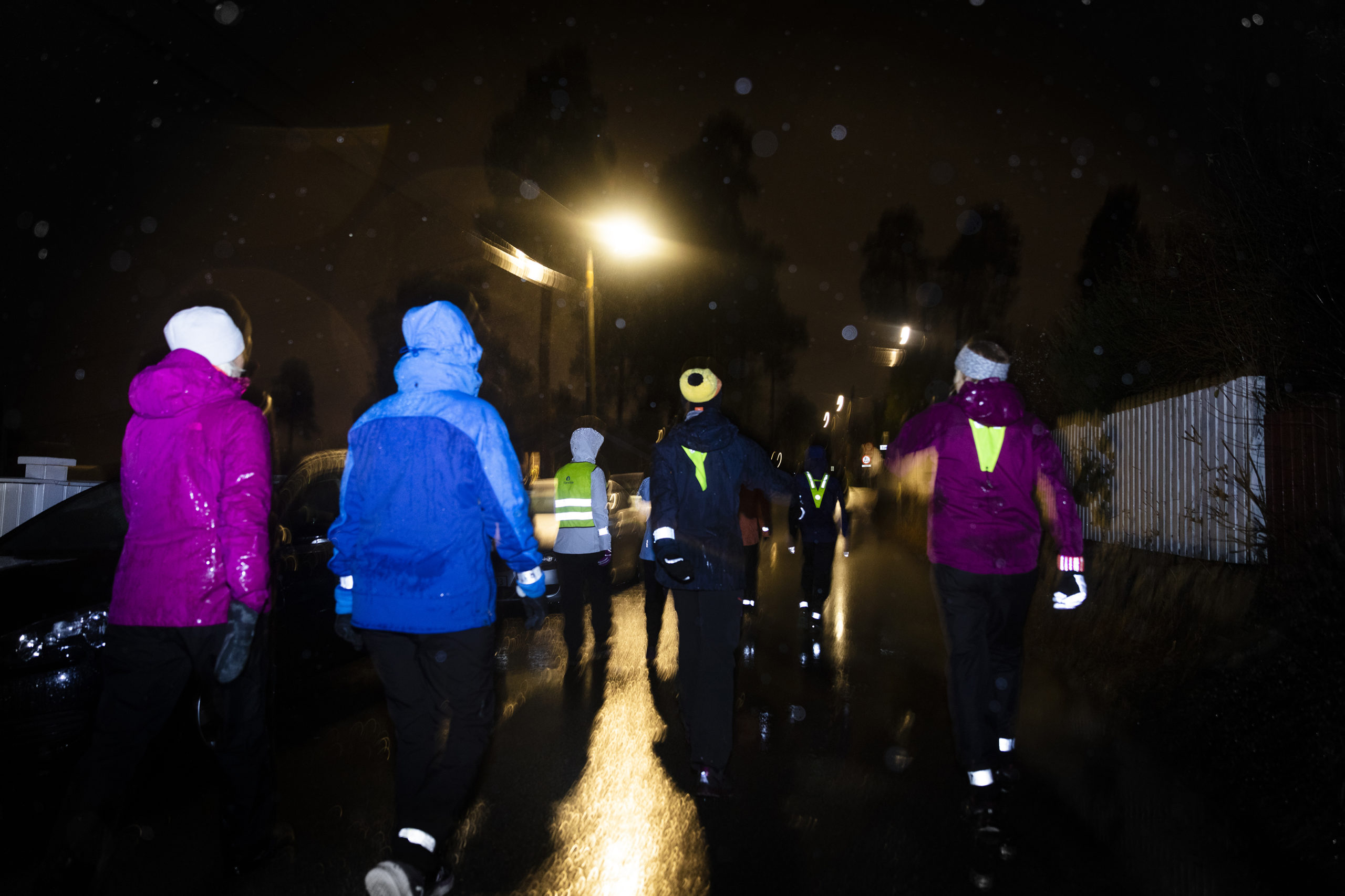 En gruppe kvinner som går en tur ute i snø eller regn.