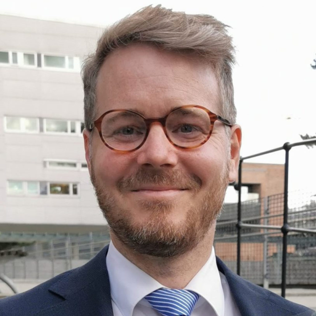 Portrettbilde av en mann som smiler til kamera.