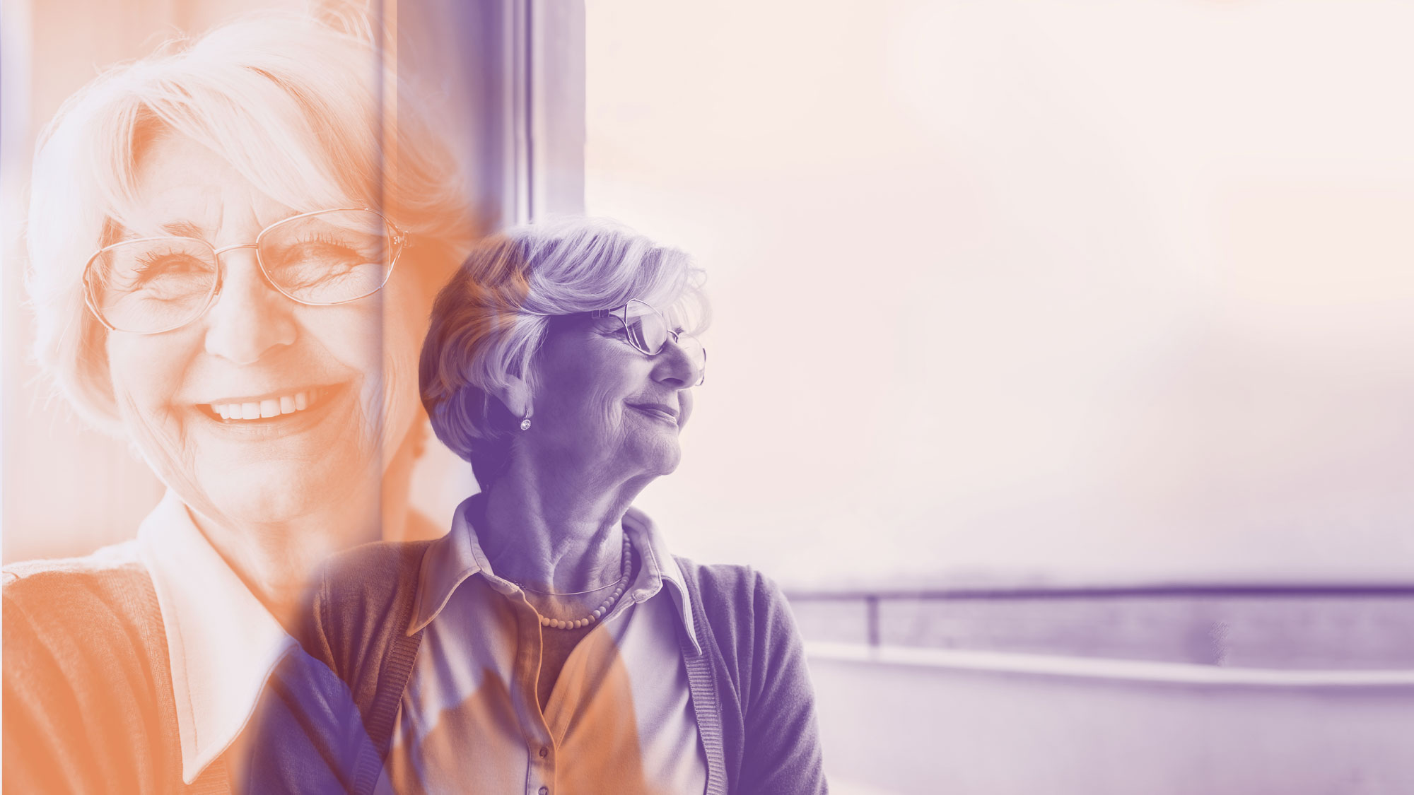 En eldre, smilende dame som kikker ut av et vindu
