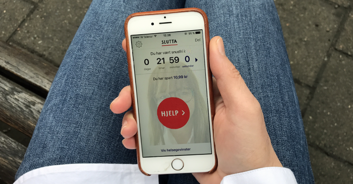 En person som holder en smarttelefon med Slutta-appen åpen.