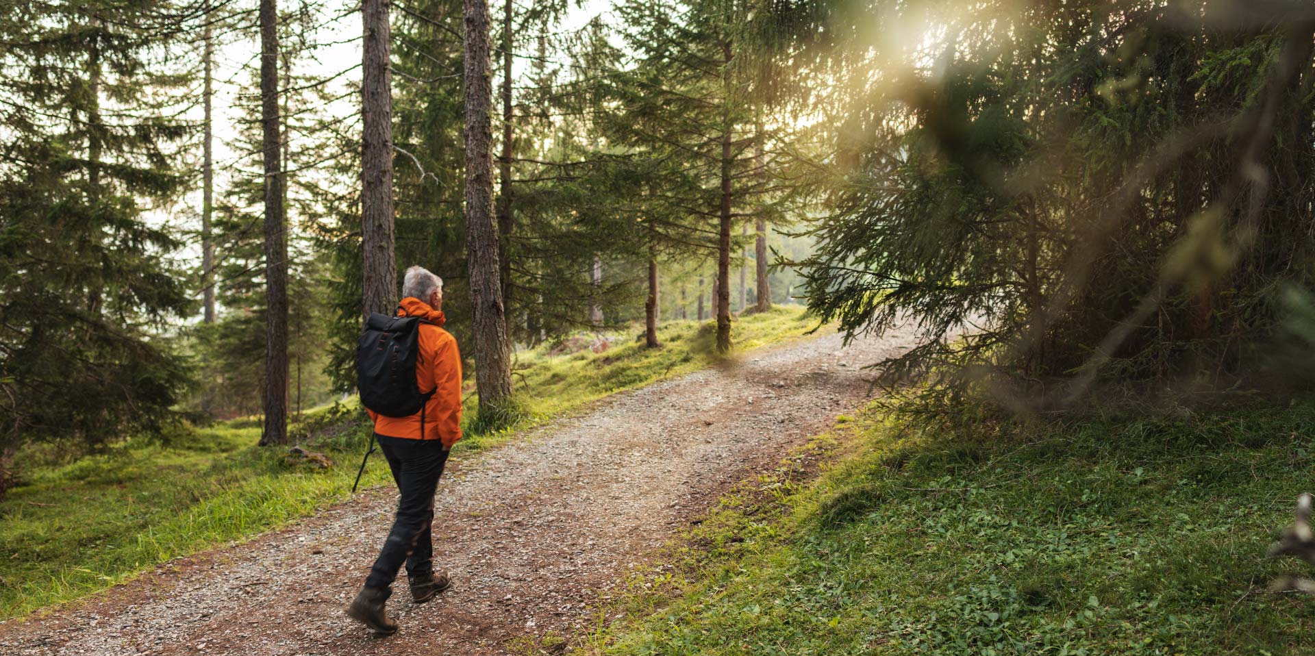 En mann ute i skogen på en sti.